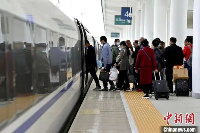 资料图:图为出行旅客正在有序排队上车中。王甜 摄