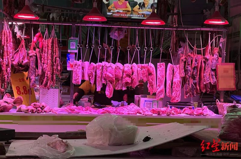 在一家菜市场内,被红色光线照亮的肉摊。