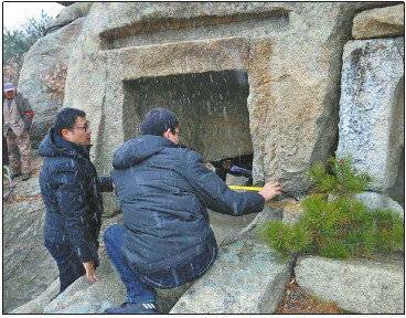 调查工作人员在烟台市牟平区连环盆石窟冒雪测绘。