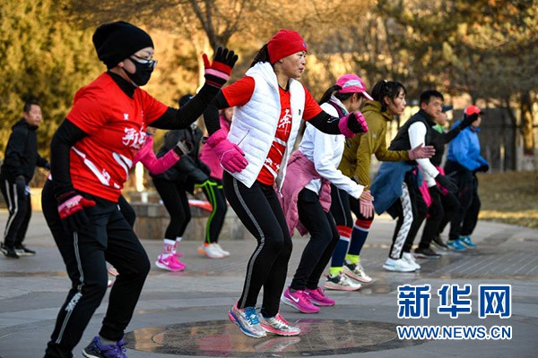 1月1日,在宁夏银川市森林公园,跑友在完成“打卡”后活动拉伸。