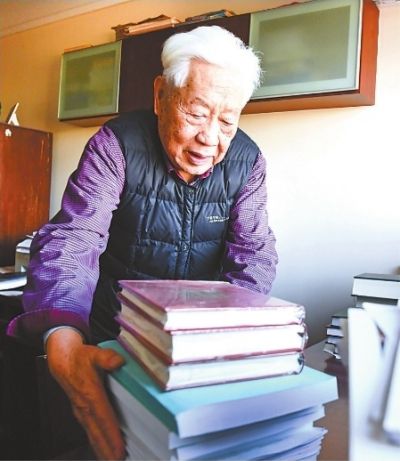 中南财经政法大学退休教授赵德馨在家中书房办公，清理案头书籍和资料。记者高勇 摄