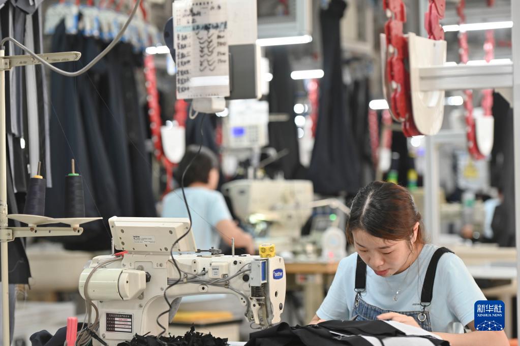 在位于福建省泉州市经济技术开发区的九牧王西裤智能化生产车间，工人在自动化西裤吊挂流水线上作业（7月30日摄）。新华社记者 宋为伟 摄