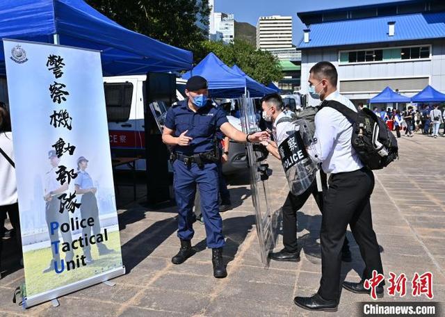 香港警队12月12日在香港警察学院举办“警察招募·体验日”。图为警察机动部队队员向参加者介绍其工作。 政府新闻网 供图