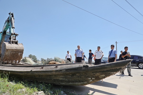  图③:长江大堤上,执法人员对收缴的各类非法捕捞工具进行集中销毁 