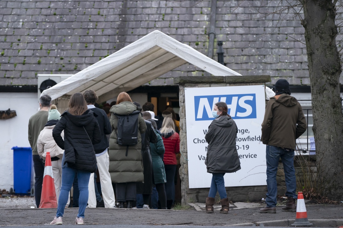 人们在英国曼彻斯特排队等待接种新冠疫苗。新华社 图