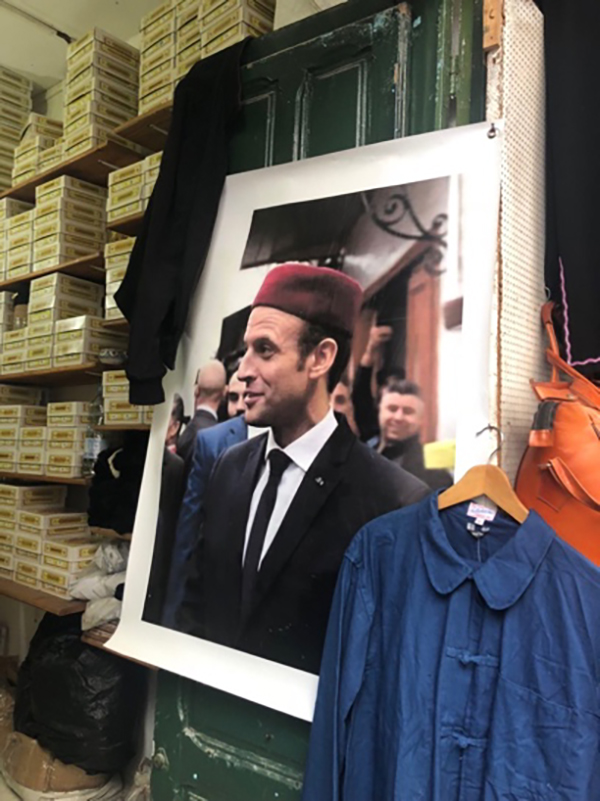 突尼斯老城的一家店铺，挂着法国总统马克龙来访的照片。 澎湃新闻记者 喻晓璇 图