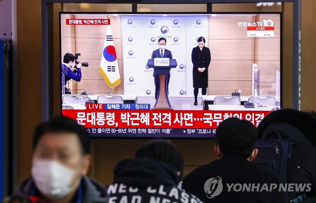 今天（24日）上午，韩国民众在首尔站观看韩国法务部长官宣布特赦的电视画面（图自韩联社）