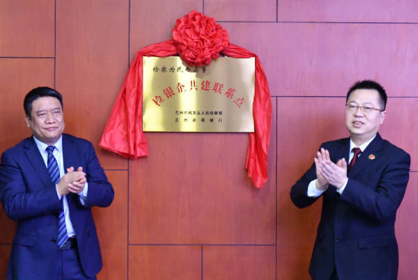 城关区检察院检察长罗涛(右)与金融机构负责人共同揭牌