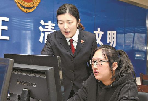  孔瑶瑶(左一)与同事在12309检察服务大厅仔细审查研判案情。 