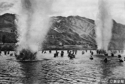 1951年7月，中国人民志愿军第20军战士们冒着炮火和敌人的阻击，涉水强渡昭阳江。张崇岫 摄