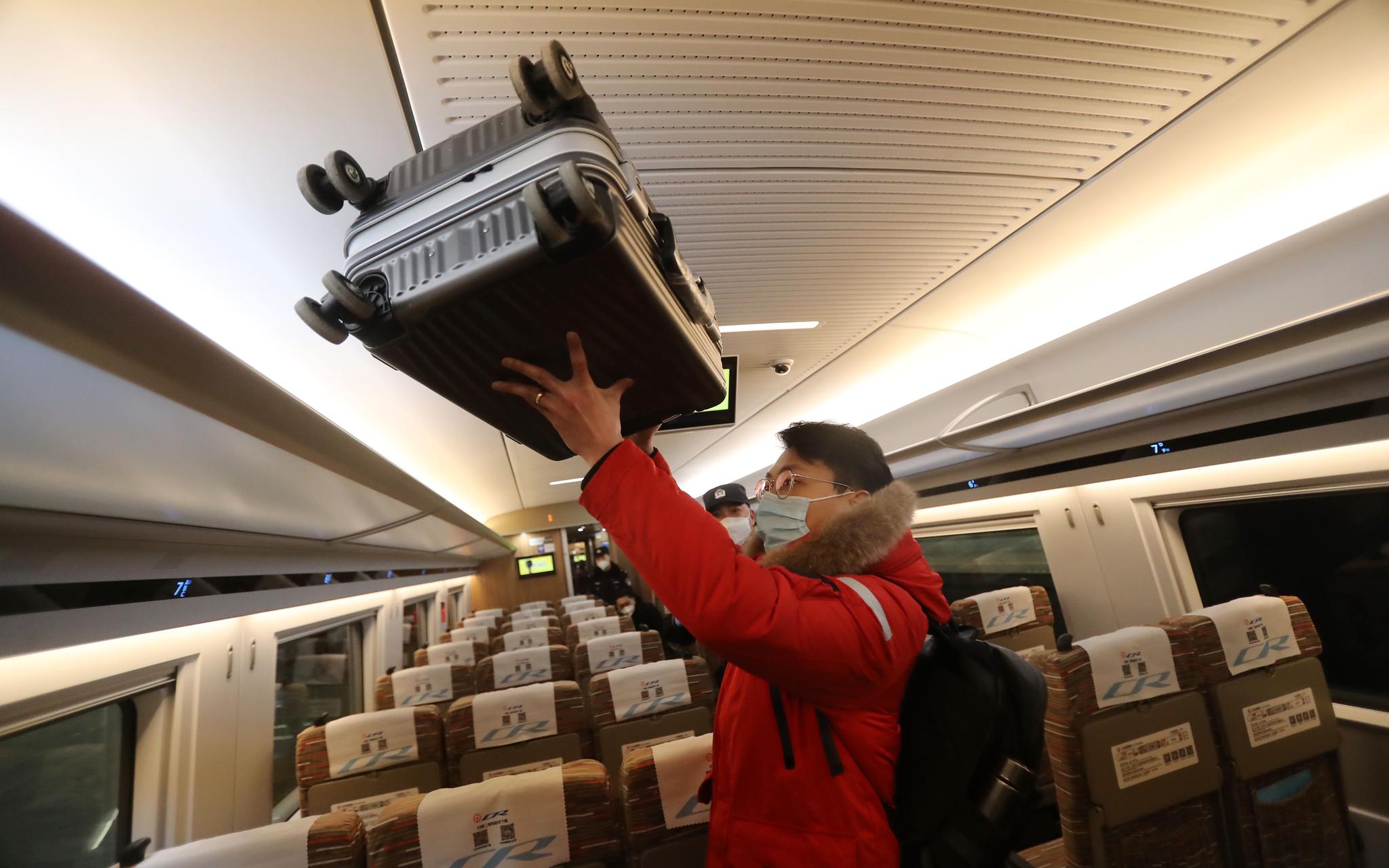 列车内,旅客在码放行李箱.摄影/新京报记者 王贵彬