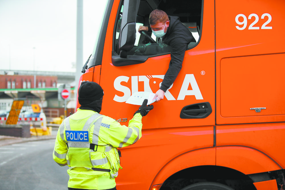 1月1日,在英国肯特郡多佛尔港,一名警察检查一名卡车司机的证件.