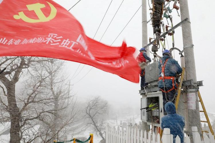 （国网威海供电公司工作人员顶风冒雪更换为变压器，保障“煤改电”村庄取暖用电 刘中华 摄）