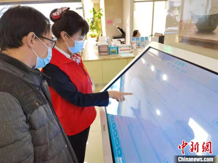 图为武威政务大厅的志愿者指导帮办业务。 史静静 摄