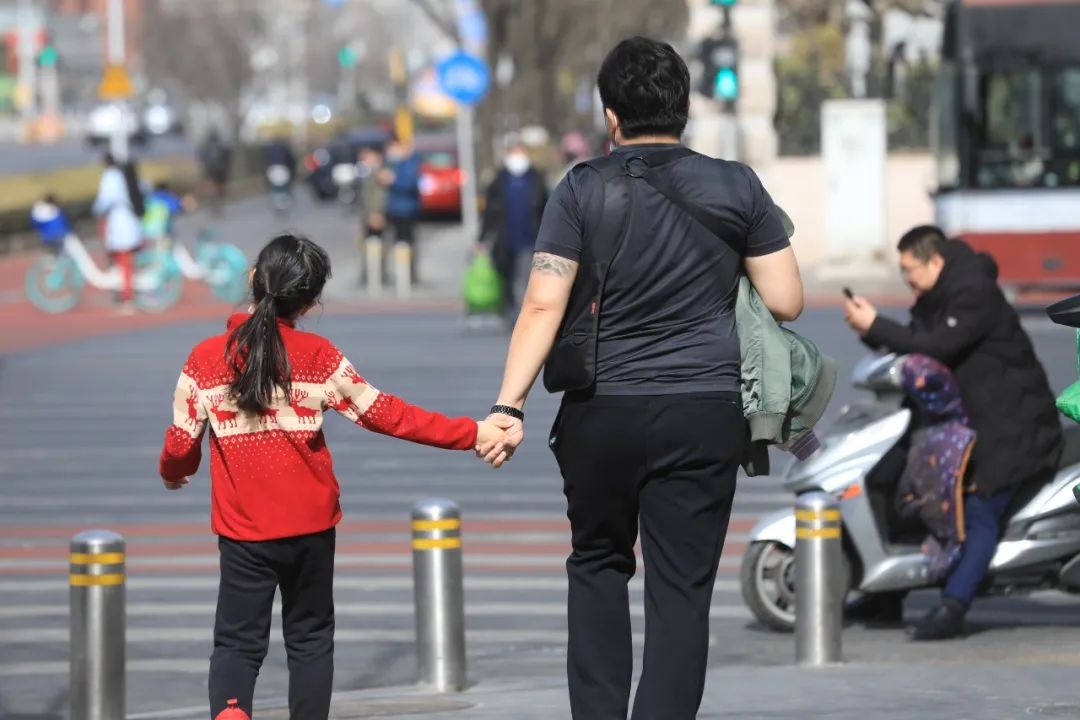 ▲2021年2月21日,北京,市民纷纷穿着“夏装”行走在路上。图源/IC photo