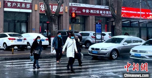 图为25日清晨，西宁市气温骤降，民众们纷纷穿上厚棉衣，戴口罩。 孙睿 摄
