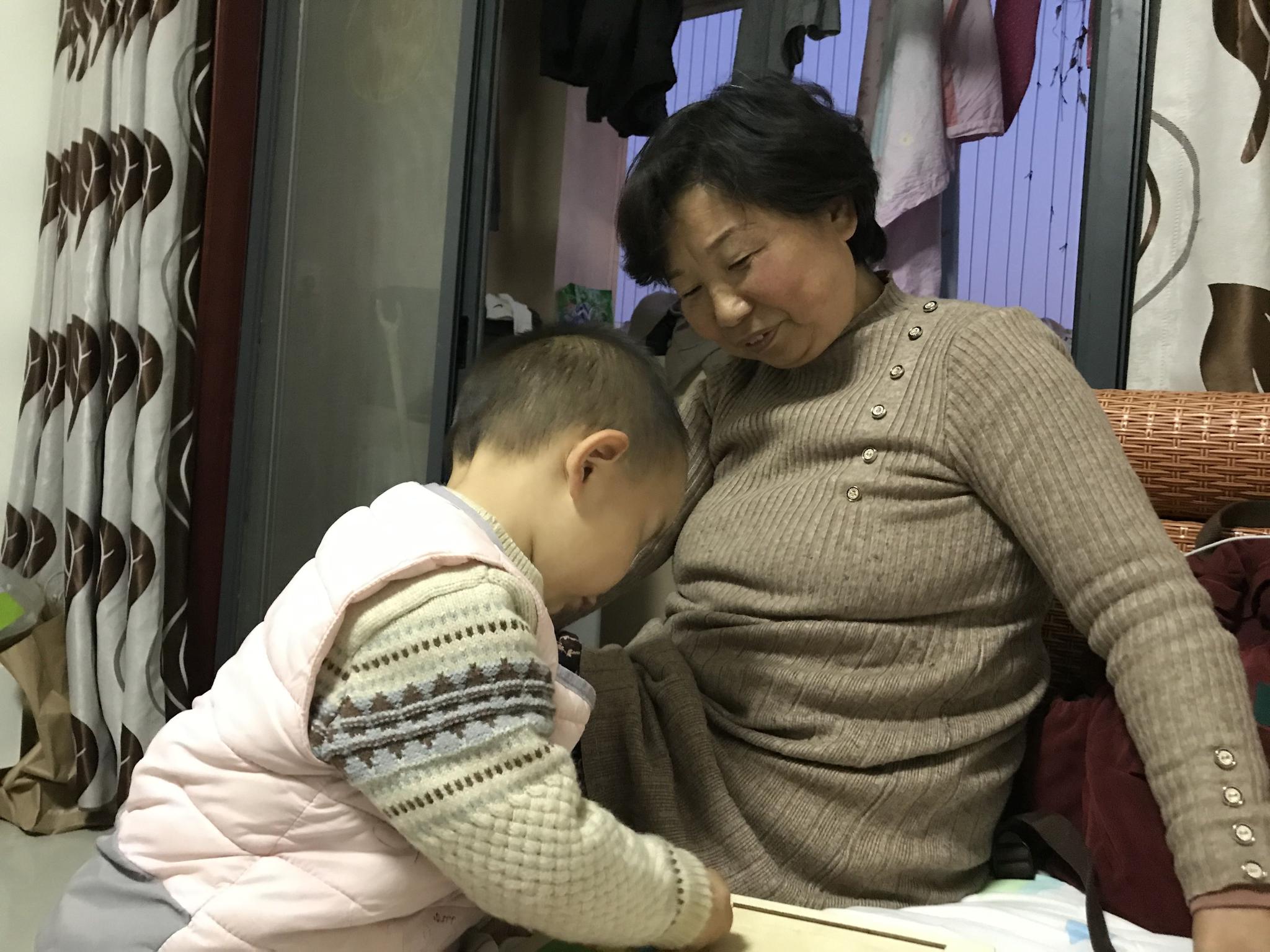 1月18日,在广西北海的出租房里,杜新枝和孙子楷楷玩耍。新京报记者 张惠兰 摄