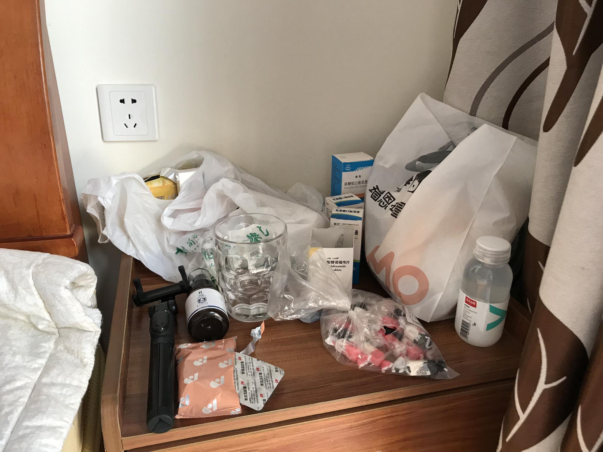 广西北海的出租房里,姚策床头柜上摆了不少药品。新京报记者 张惠兰 摄