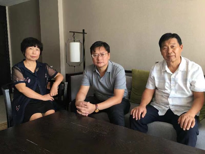 案件一审开庭前,杜新枝、郭希宽(右)与代理律师。受访者供图