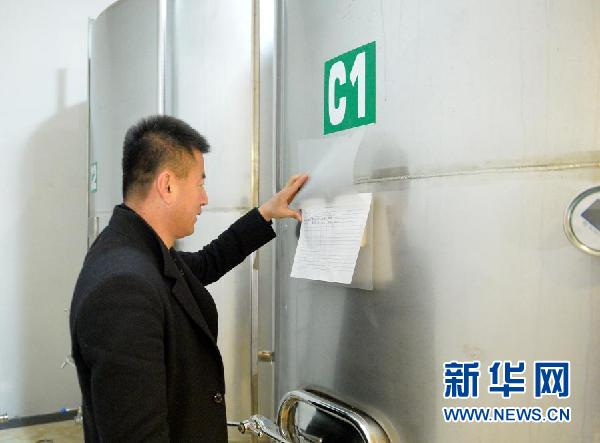 酿酒师李财检查发酵罐数据(1月6日摄)。新华社记者 唐如峰 摄