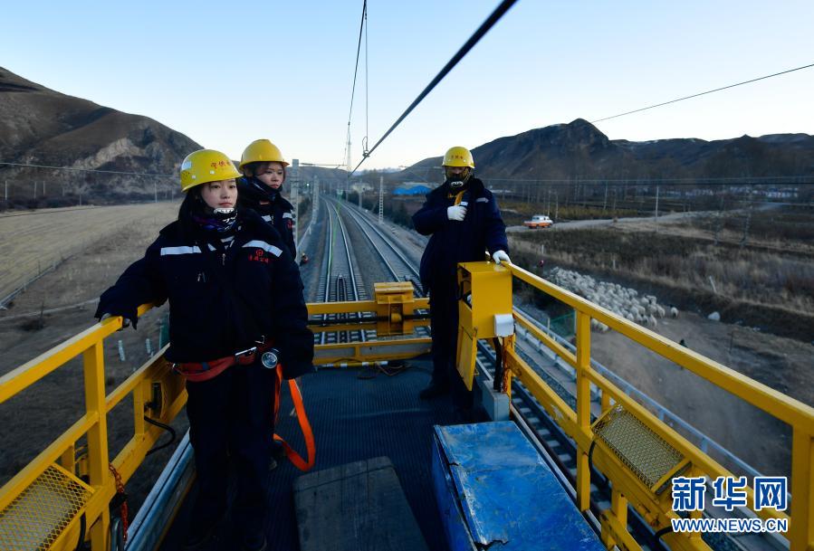   2月2日，在青藏铁路公司西宁供电段哈尔盖工区负责铁路线上，郭胜强（左一）与罗露露（左二）在高空作业平台上准备工作。新华社记者 张龙 摄