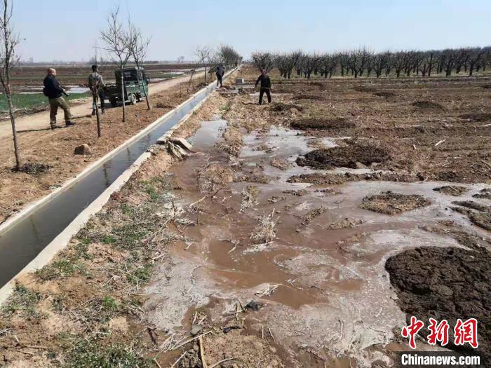 当地村民抓住时机忙春浇。 李新锁 摄
