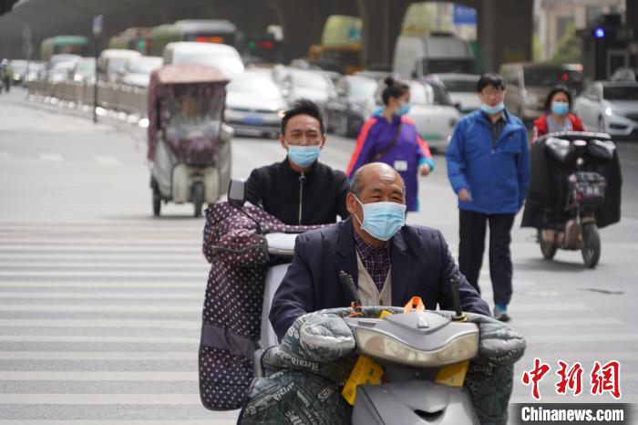 浮尘天气，郑州市民戴口罩出行。　韩章云 摄