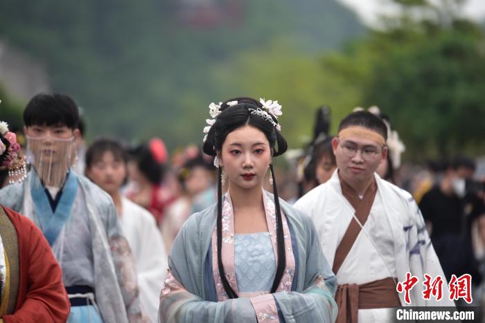 一位女子穿着中国风服饰在巡游队伍中。 王以照 摄