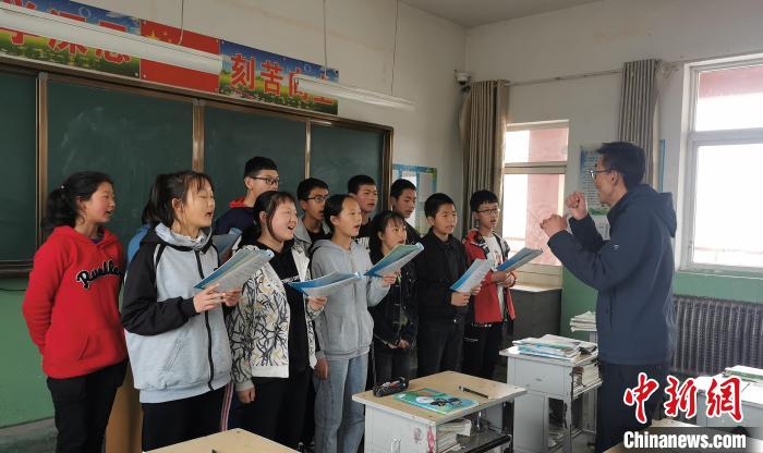 静乐县丰润中学音乐教师李晓斌正在给学生上音乐课。 杨杰英 摄