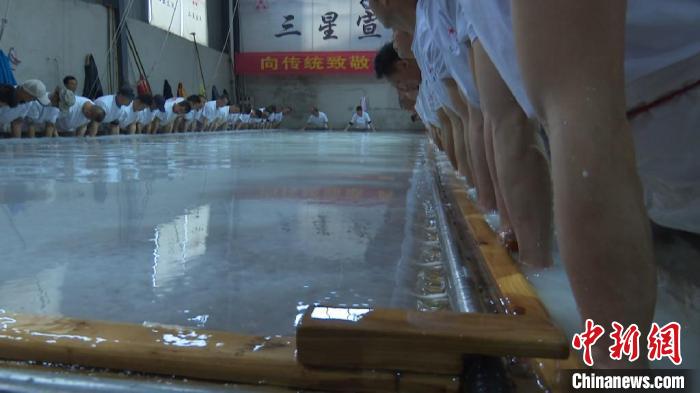 捞纸师傅们将巨型的纸帘放入纸槽中进行捞制。　刘鸿鹤 摄