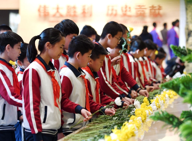 2019年4月4日,学生代表在北京中国人民抗日战争纪念馆向抗战英烈献花。新华社记者 张晨霖 摄