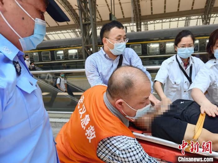 参与救援的姚文龙医生和陈姓护士互送晕倒乘客上救护车。　郑州铁路公安供图