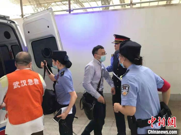 姚文龙(中间戴眼镜男士)与乘警一同将晕倒乘客送上救护车才离去。　郑州铁路公安处供图