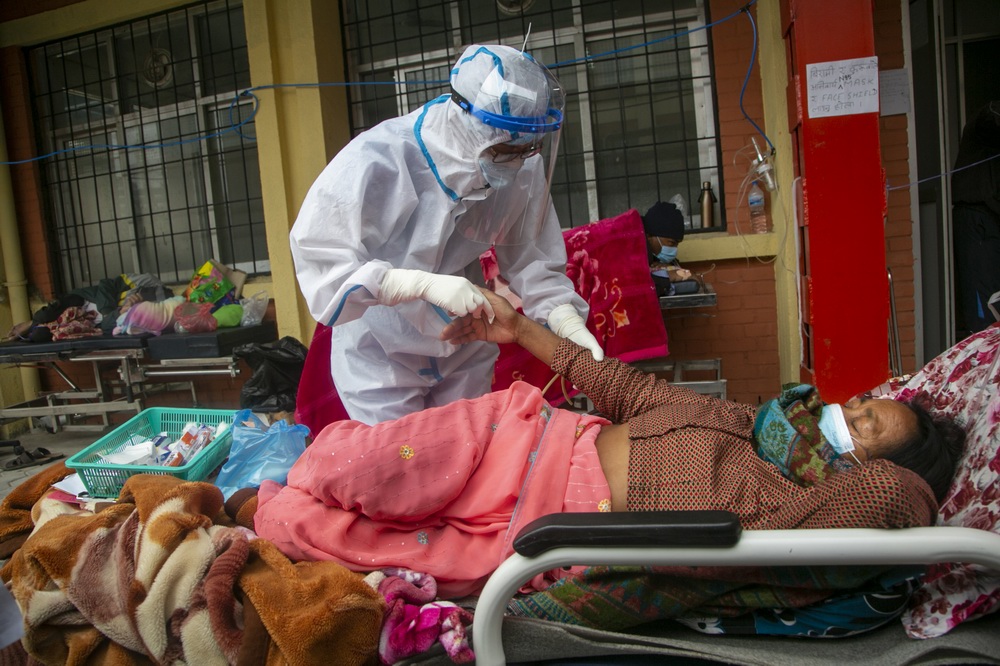 当地时间2021年5月10日，尼泊尔加德满都，医护人员照顾病房外的患者。