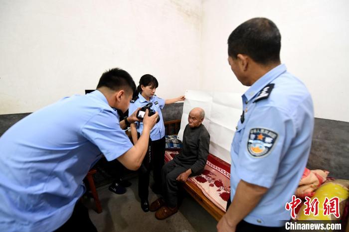 图为挂村民警上门为93岁老人办理二代身份证。　王东明 摄