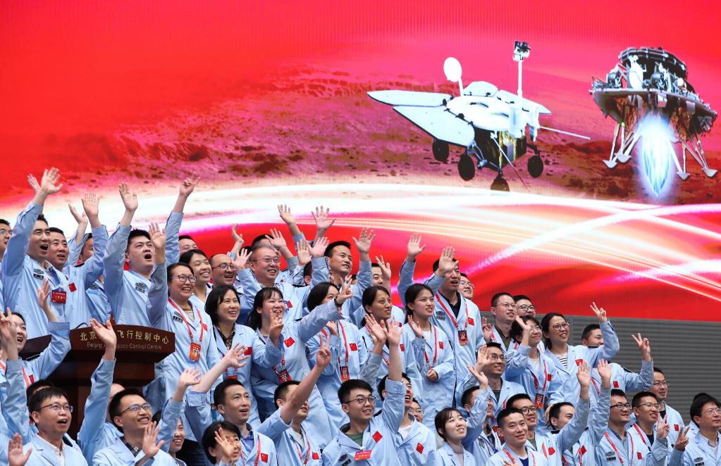 5月15日,航天科研人员在北京航天飞行控制中心指挥大厅庆祝我国首次火星探测任务着陆火星成功。新华社记者金立旺摄
