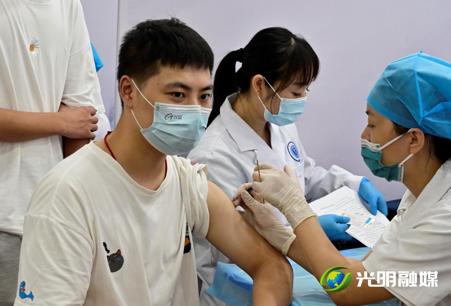 医护人员正在给一位市民接种新冠疫苗。
