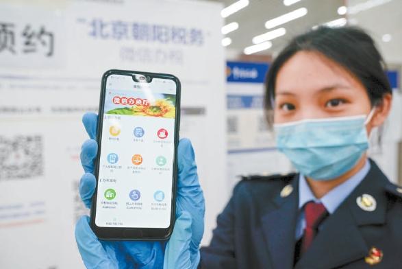 在朝阳区税务局办税服务厅,工作人员在展示微信办税界面。本报记者 武亦彬摄