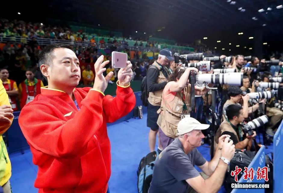 里约奥运会乒乓球男子单打决赛,马龙战胜卫冕冠军张继科夺得冠军,成为世界上第五个实现大满贯的男子选手。图为刘国梁用手机记录精彩瞬间。中新网记者 杜洋 摄