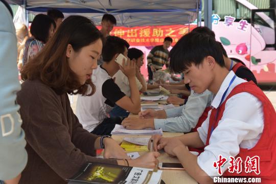 资料图:大学生在爱心献血点咨询献血活动。 邓天运 摄