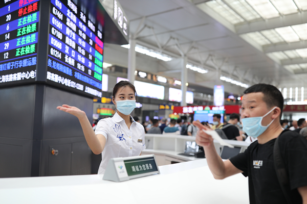 图说:上海虹桥站服务台客运员解答旅客问询 过云松 摄