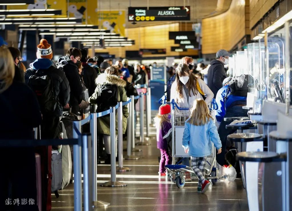 当地时间2021年12月27日，美国西雅图，旅客在机场。据报道，由于新冠变异病毒奥密克戎毒株导致美国新冠确诊病例激增，机场多架次航班被取消。图源：澎湃影像