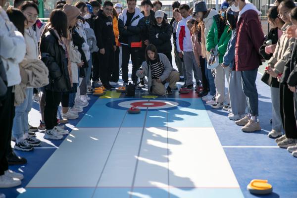  中央民族大学体育文化月旱地冰壶体验活动吸引学生参与。