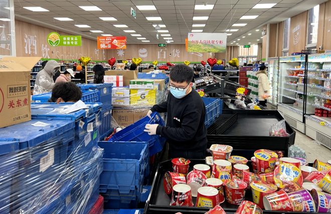 ▲超市工作人员正在整理新到的商品