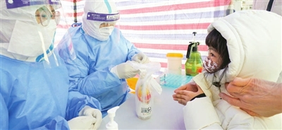 12日，河西区第二幼儿园核酸检测点，一位小朋友做完检测向医生“比心”。