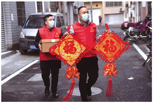 一月十一日，杭州市临安区高虹镇的党员志愿者上门给准备留在当地过年的外来务工人员送上“福”字和新春大礼包。新华社记者徐昱摄