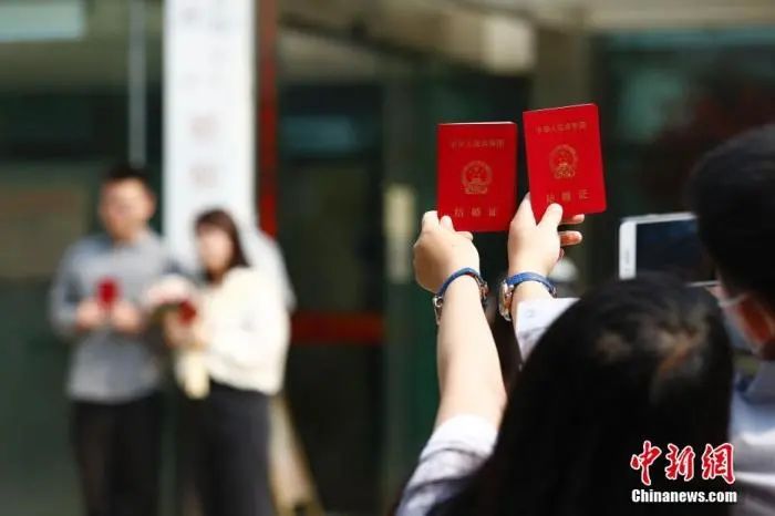 资料图:新人在民政局婚姻登记处外拍照留念。中新社记者 富田 摄