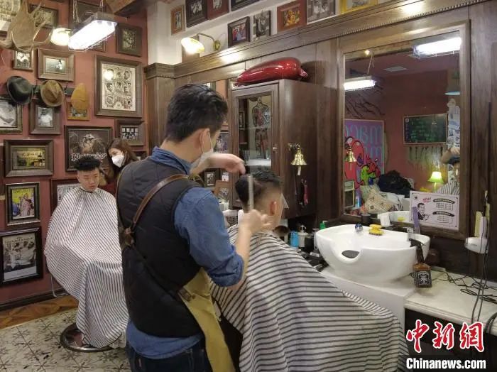 西安黑桃理发店内，顾客正在剪发。 党田野 摄