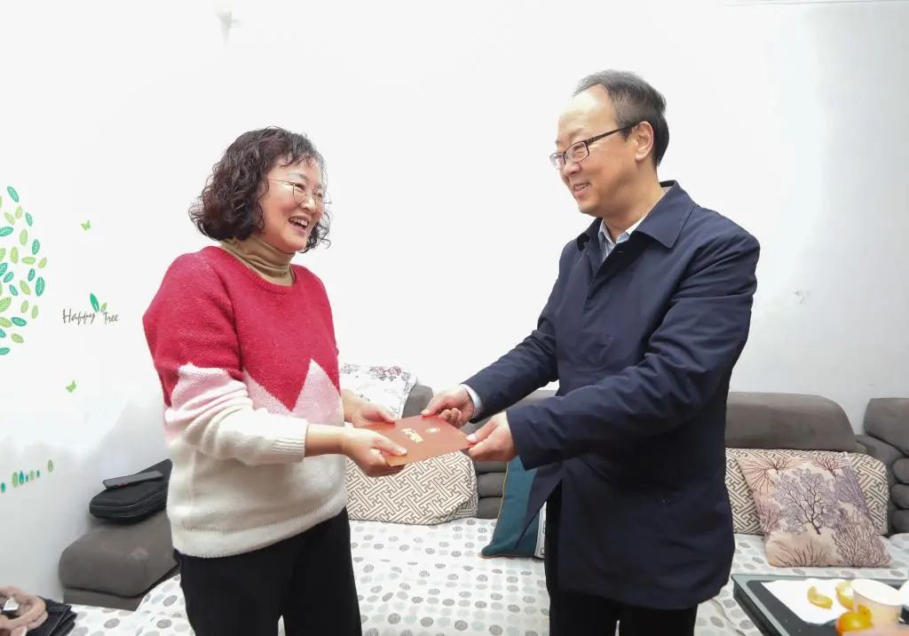 校党委书记肖远平（右）看望慰问驻村第一书记蒙松林的家属
