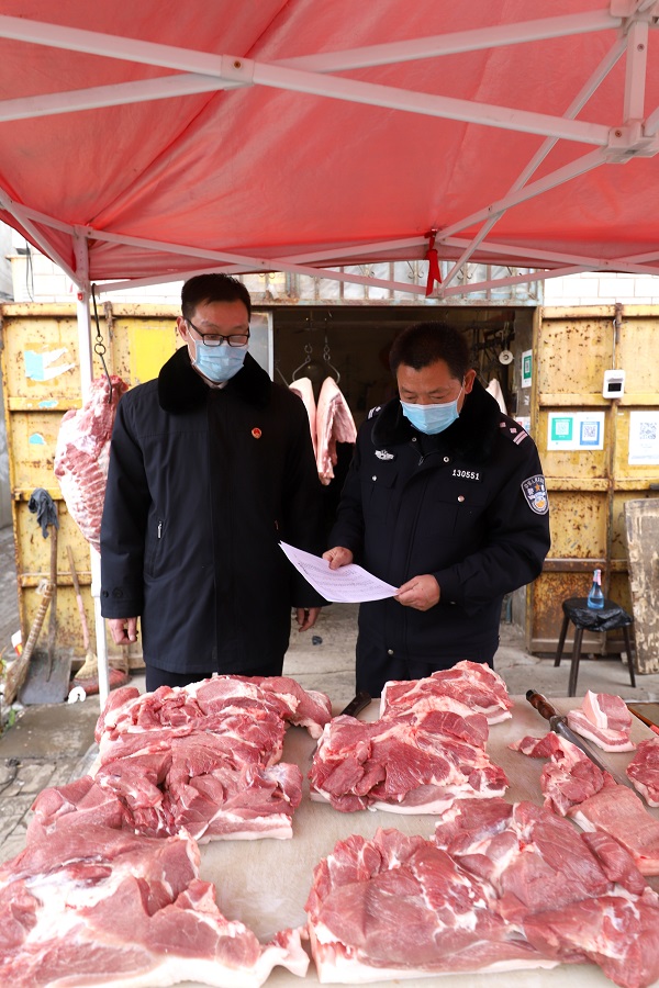 图为检察官正在猪肉售卖摊点检查进货查验和索证索票记录。检察日报通讯员任寒霜摄